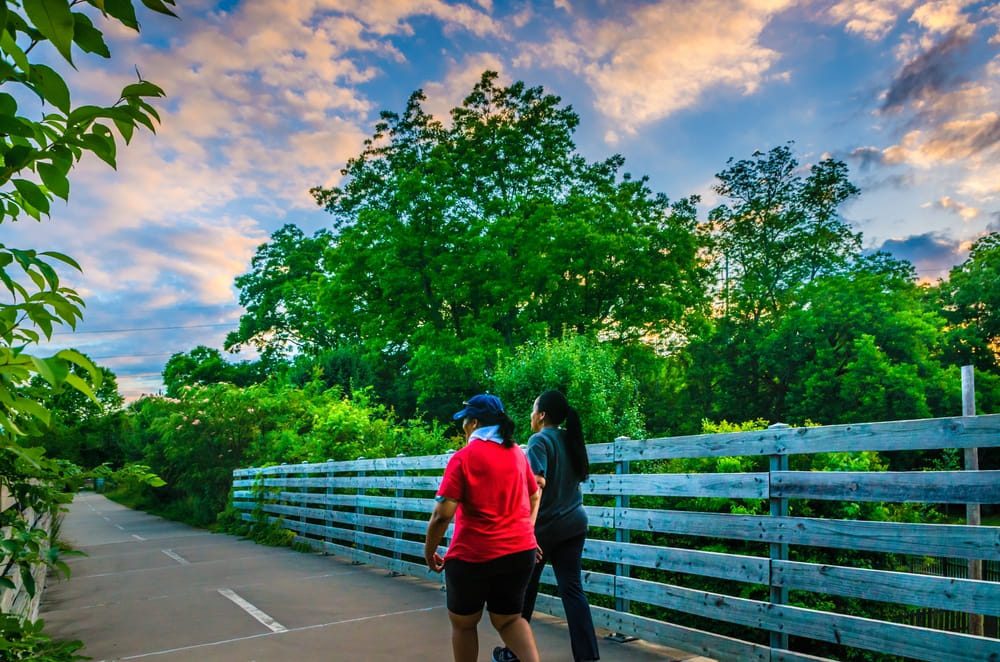Walkers cross a bridge along the Stone Mountain Village walking trail in Stone Mountain, Georgia